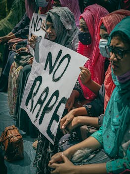 Group of women holding signs protesting against rape, highlighting social issues and activism.