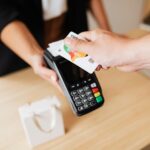Close-up of contactless payment using a credit card at a modern POS terminal.