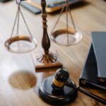 A striking image featuring a brass justice scale and gavel on a wooden desk, symbolizing law and justice.