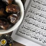 A bowl of dates with Quran, symbolizing Ramadan iftar tradition.